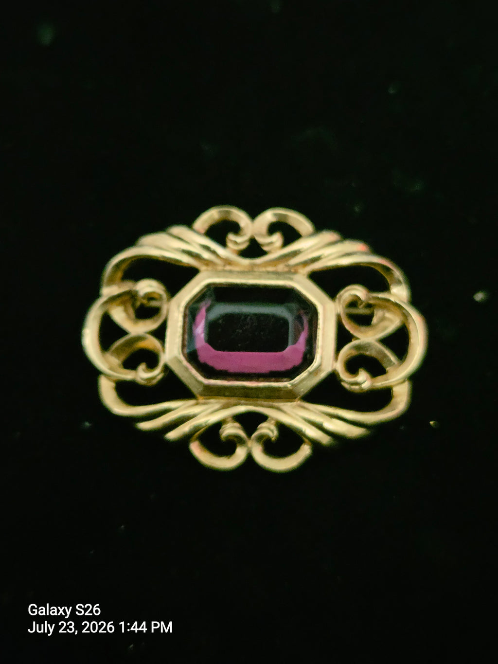 Elegant goldtone brooch with vibrant faux amethyst
